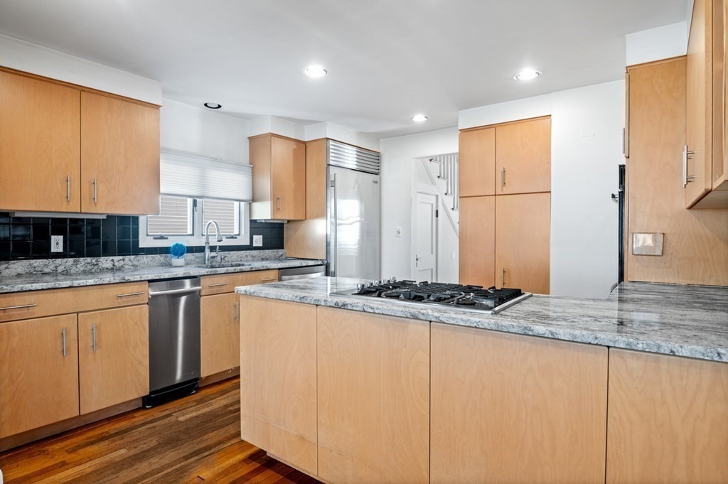 6 Stone Street Saugus, MA 01906 - Photo 7 of 39 a kitchen with stainless steel appliances granite countertop a sink and a refrigerator