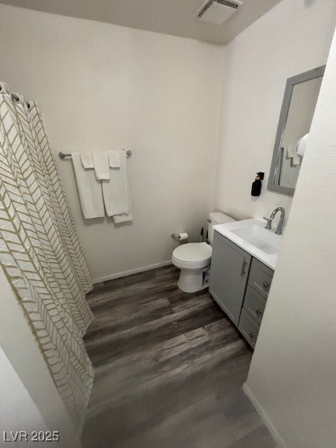4640 Koval Lane, Unit 49C Las Vegas, NV 89109 - Photo 9 of 12 Bathroom featuring wood finished floors, vanity, toilet, and baseboards