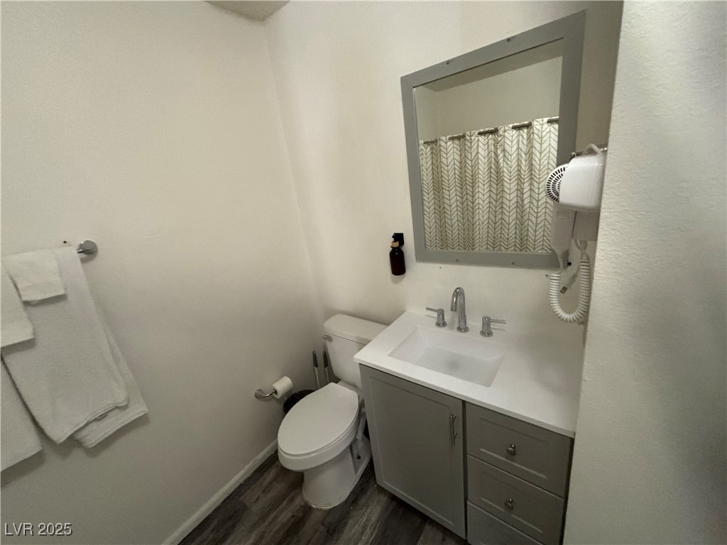 4640 Koval Lane, Unit 49C Las Vegas, NV 89109 - Photo 10 of 12 Full bath featuring wood finished floors, vanity, toilet, and baseboards