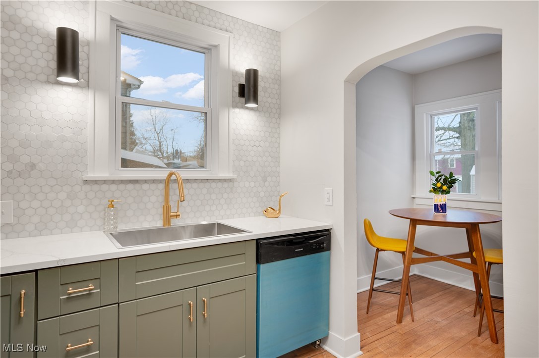 2016 Rossmoor Road Cleveland Heights, OH 44118 - Photo 22 of 46 Kitchen with dishwasher, arched walkways, decorative backsplash, light wood finished floors, and light stone countertops