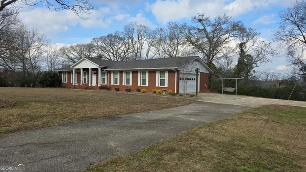 a front view of house with yard and trees around