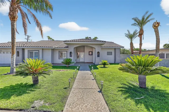a front view of a house with a garden and plants