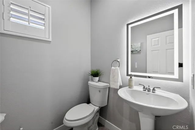 a spacious bathroom with double vanity a mirror a lamp and a bathtub