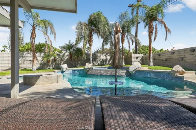 a view of a house with swimming pool and sitting area