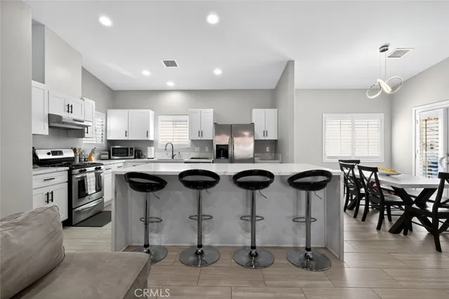 a kitchen with cabinets stainless steel appliances and a window