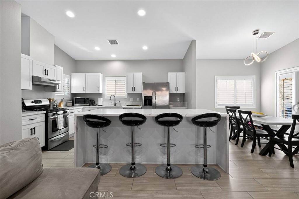 2120 West Nicola Road Palm Springs, CA 92262 - Photo 8 of 30 a kitchen with a dining table chairs and white cabinets
