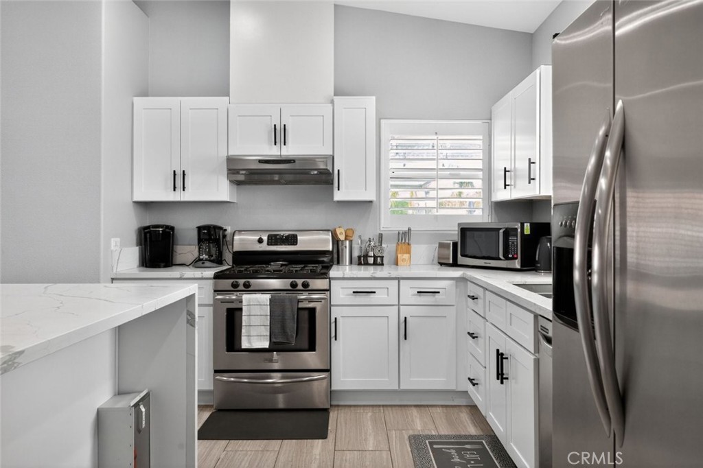 2120 West Nicola Road Palm Springs, CA 92262 - Photo 9 of 30 a kitchen with cabinets stainless steel appliances and a window