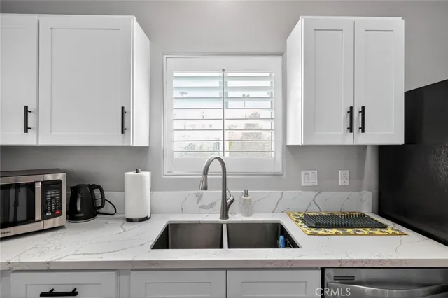 a kitchen with cabinets stainless steel appliances and a sink