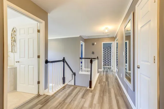a view of a hallway with wooden floor and staircase
