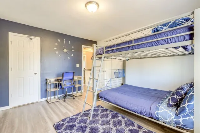 a bedroom with a bed and a bookshelf with wooden floor
