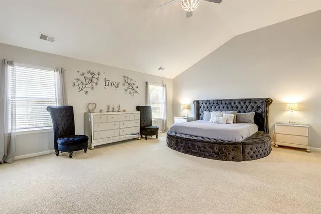 a spacious bedroom with a bed chair and a window