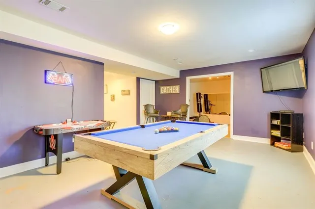 a room with pool table and windows