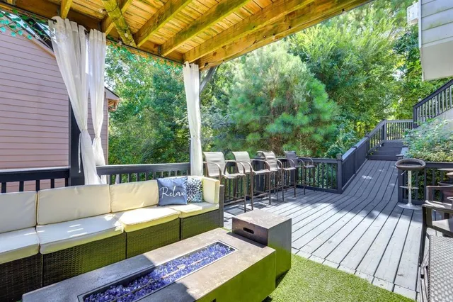 a view of a patio with couches chairs potted plants and a table and chairs with wooden floor