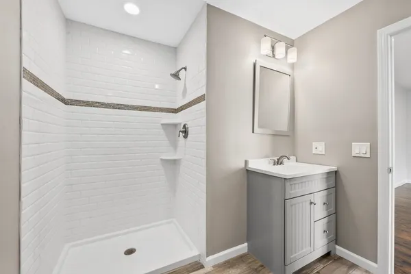 a bathroom with a sink a shower and mirror