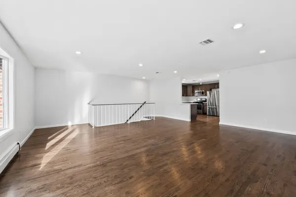 a view of empty room with wooden floor