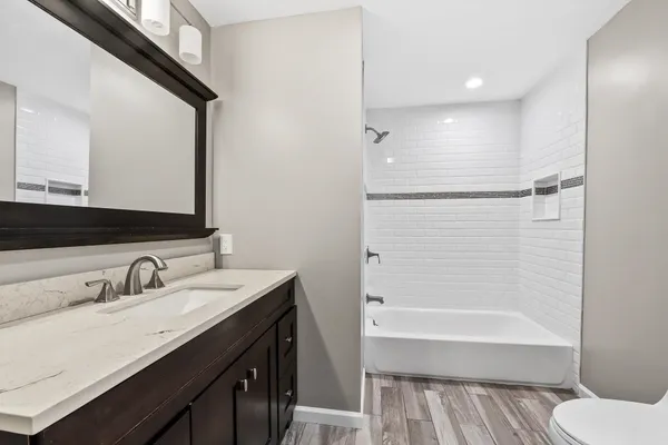a bathroom with a granite countertop sink toilet and shower