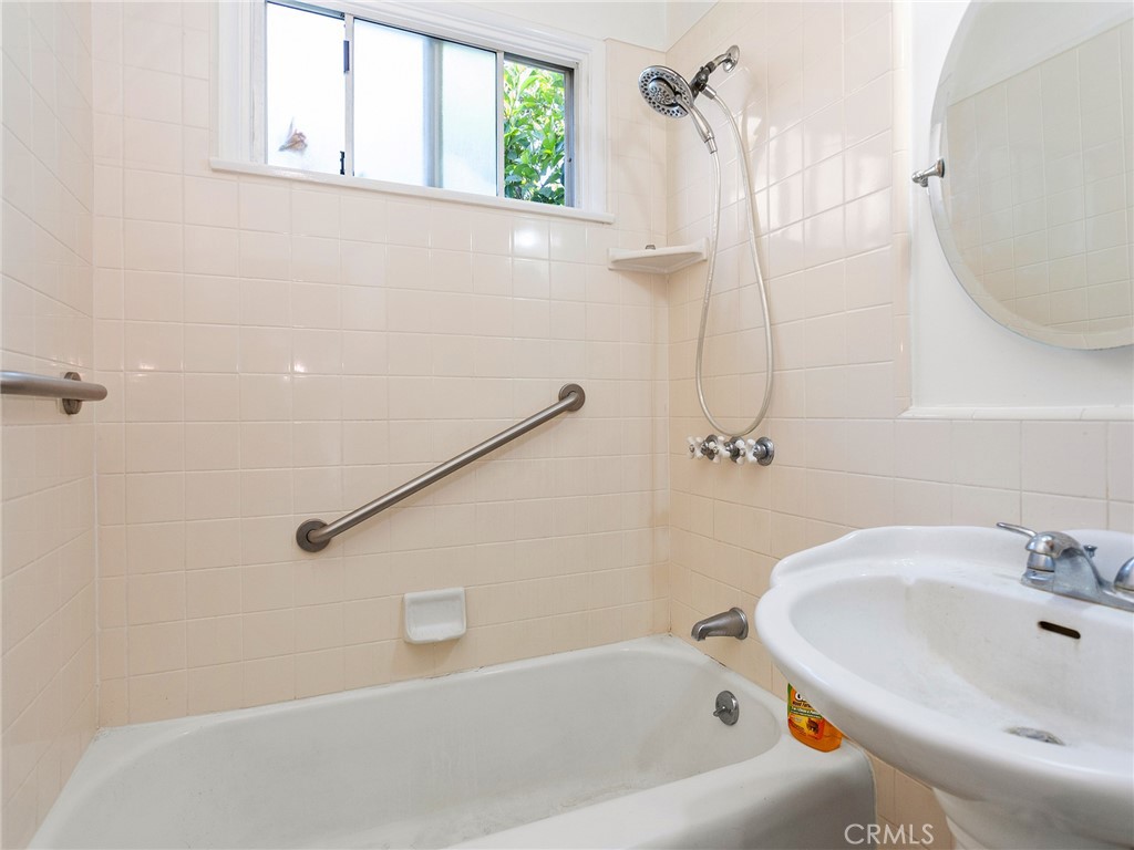2724 Scott Road Burbank, CA 91504 - Photo 20 of 43 a bathroom with a white bath tub sitting next to a white sink and a wooden floor