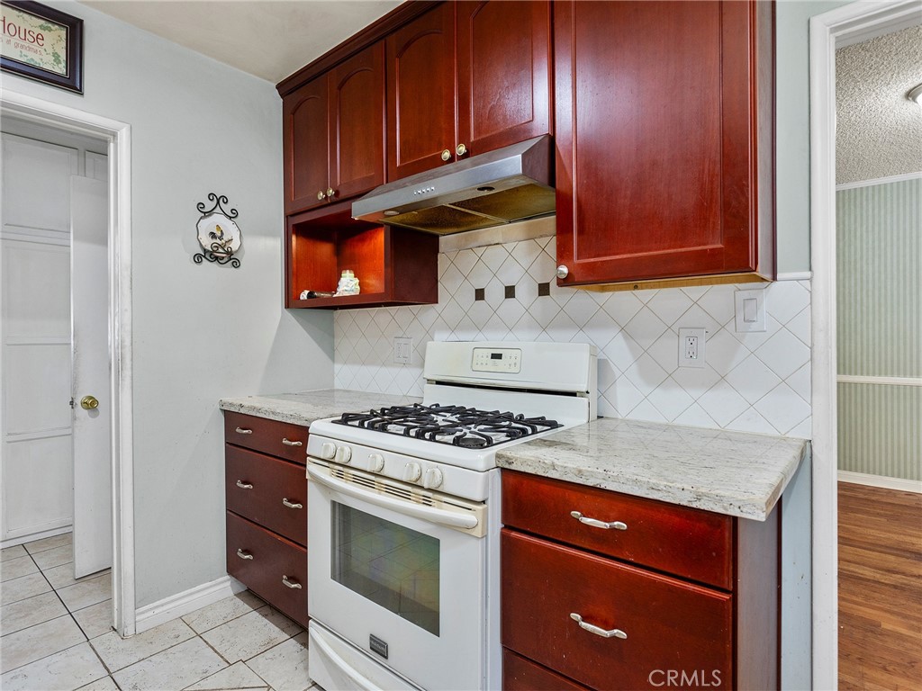 2724 Scott Road Burbank, CA 91504 - Photo 10 of 43 a kitchen with stainless steel appliances granite countertop wooden cabinets stove top oven and sink