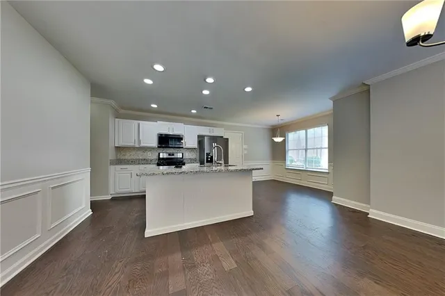 a view of kitchen with stainless steel appliances granite countertop a stove a sink and a refrigerator