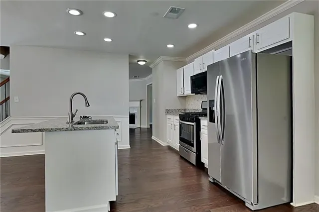 a kitchen with kitchen island a sink stainless steel appliances and cabinets