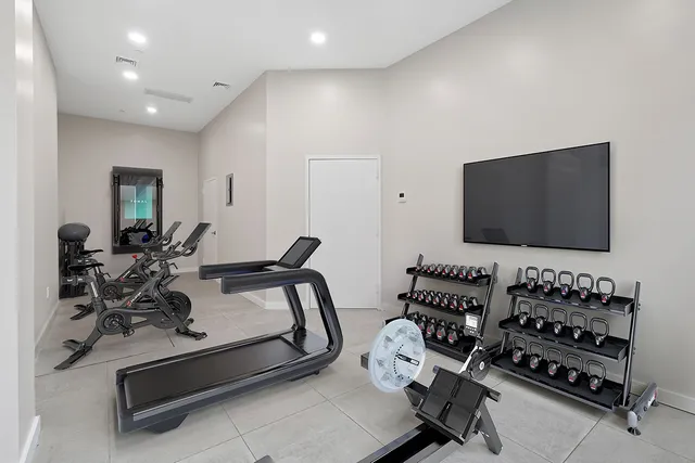 a living room with furniture gym equipment and a flat screen tv