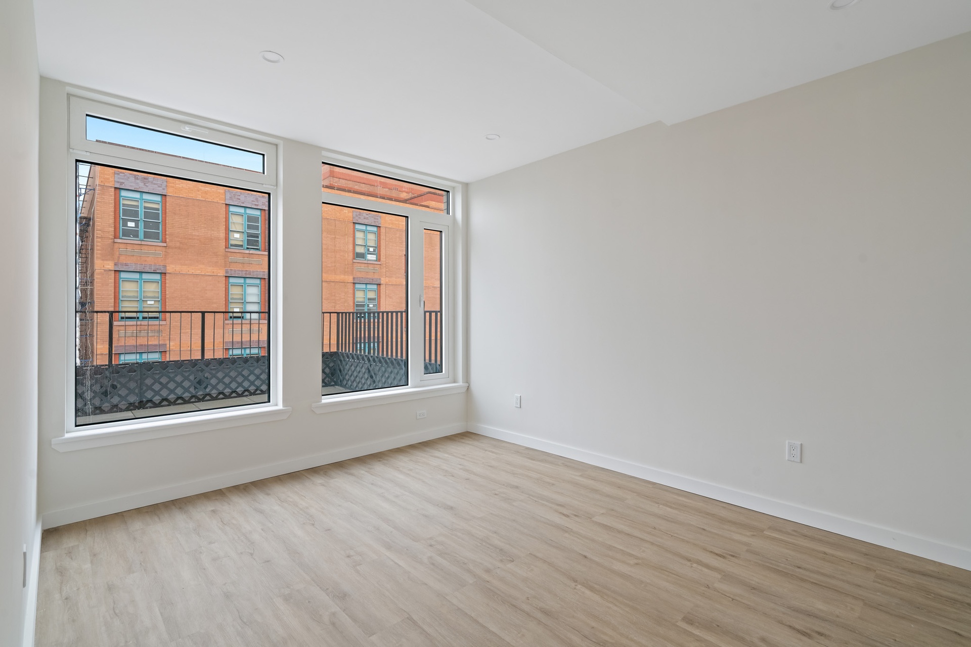 14-41 Broadway, Unit 6C Queens, NY 11106 - Photo 3 of 13 a view of an empty room with wooden floor and a window