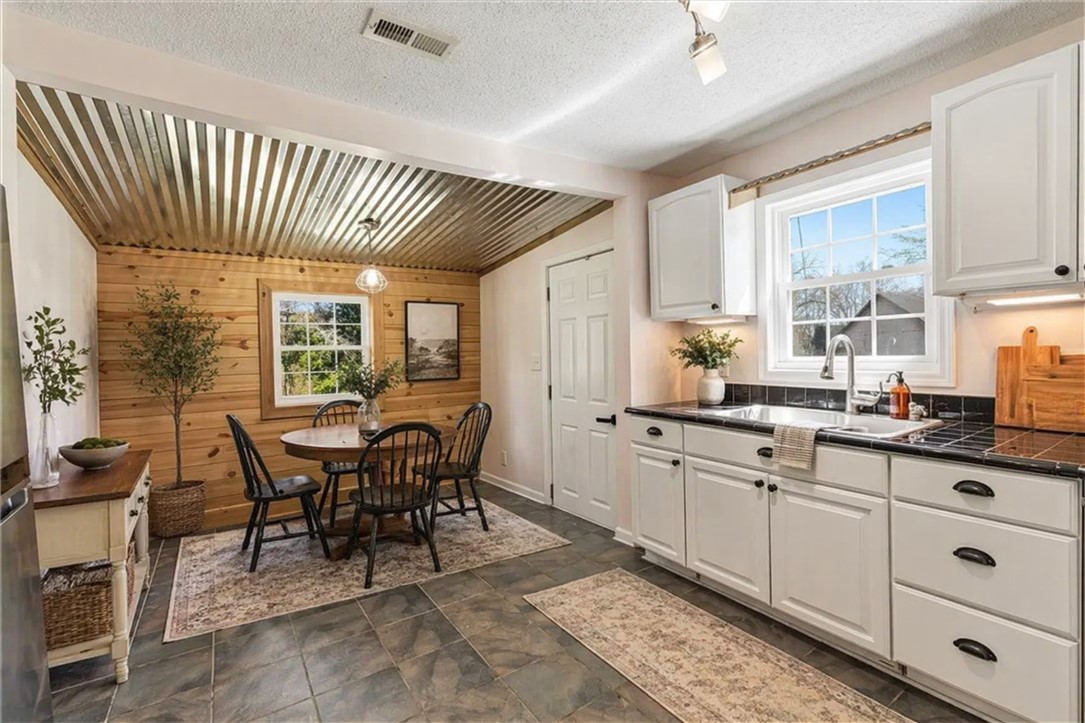 112 Newry Road Seneca, SC 29672 - Photo 5 of 19 This inviting kitchen and dining area features natural wood accents and durable tile flooring.