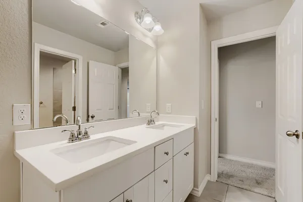 a bathroom with double sink and a mirror