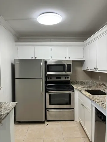a kitchen with stainless steel appliances granite countertop a refrigerator sink and stove