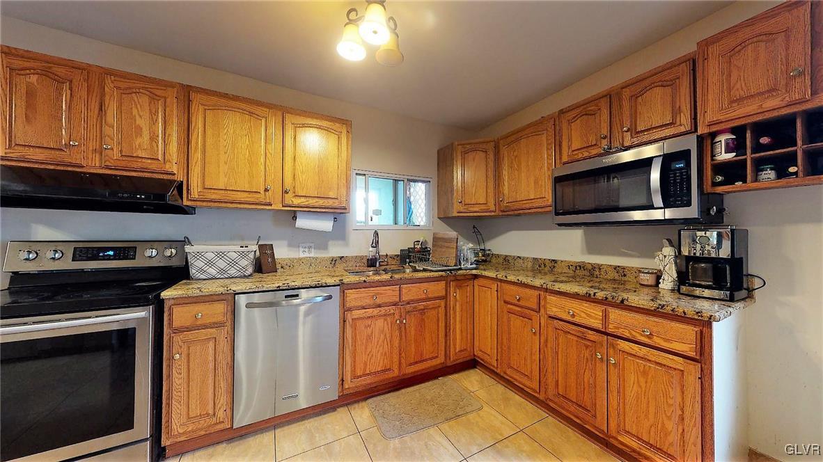 712 2nd Street Catasauqua, PA 18032 - Photo 11 of 36 a kitchen with stainless steel appliances granite countertop a stove sink microwave and cabinets