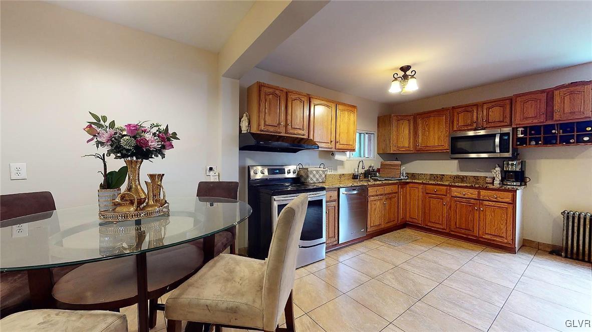 712 2nd Street Catasauqua, PA 18032 - Photo 13 of 36 a kitchen with a chandelier stainless steel appliances and dining table