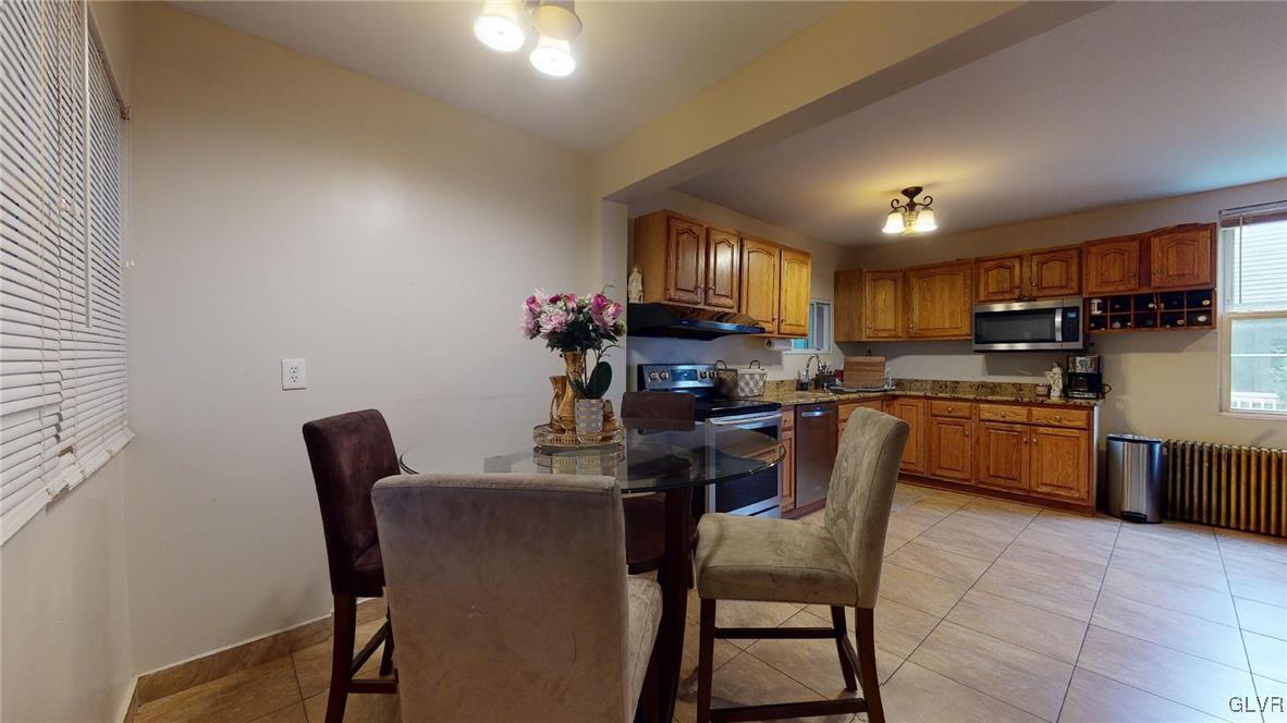 712 2nd Street Catasauqua, PA 18032 - Photo 14 of 36 a kitchen with a dining table chairs and refrigerator