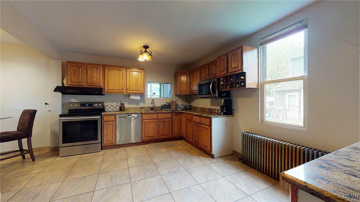 712 2nd Street Catasauqua, PA 18032 - Photo 10 of 36 a kitchen with granite countertop a stove a sink dishwasher and a refrigerator with wooden cabinets