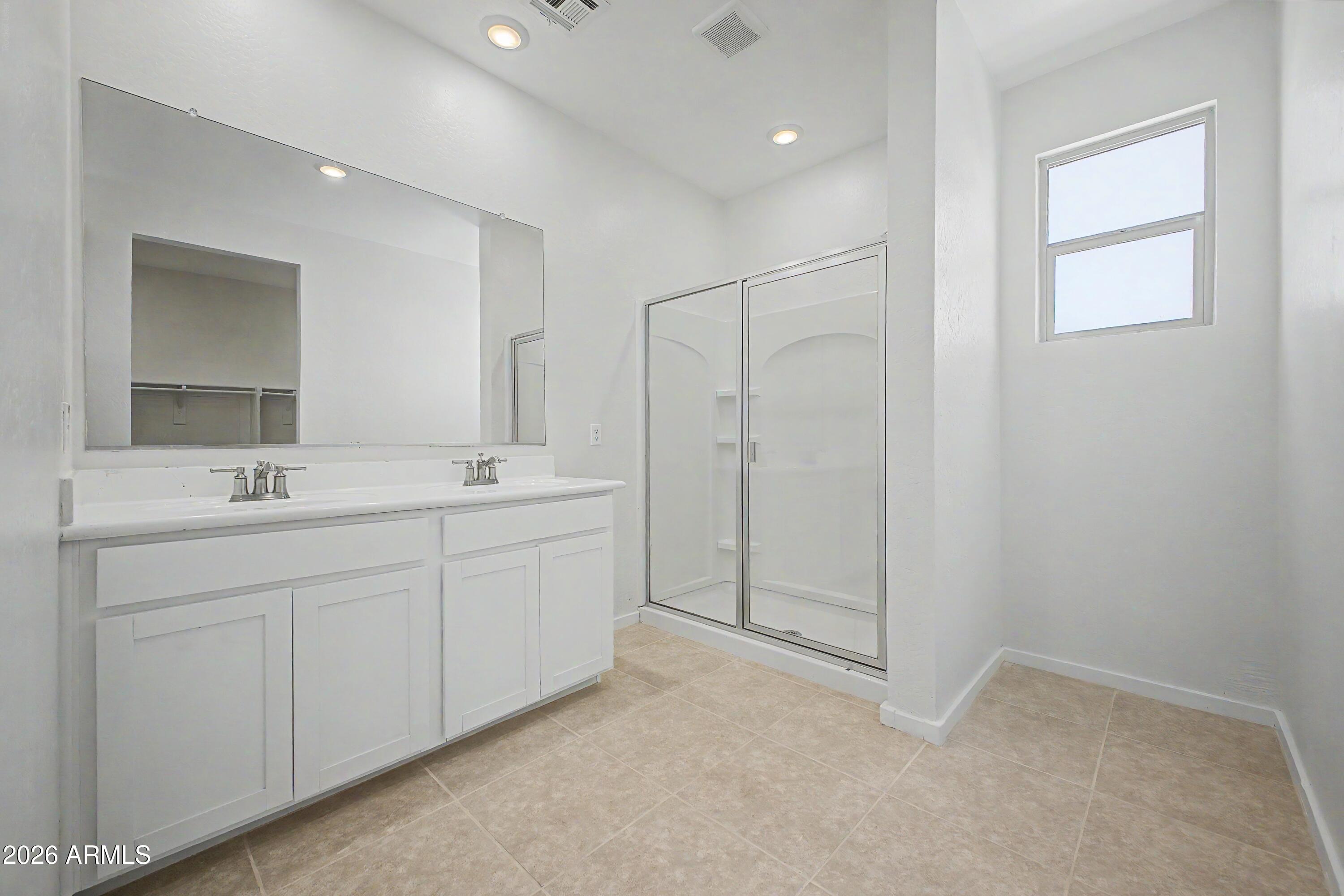 37154 North Navarra Road San Tan Valley, AZ 85140 - Photo 15 of 25 a spacious bathroom with a shower a sink and a mirror