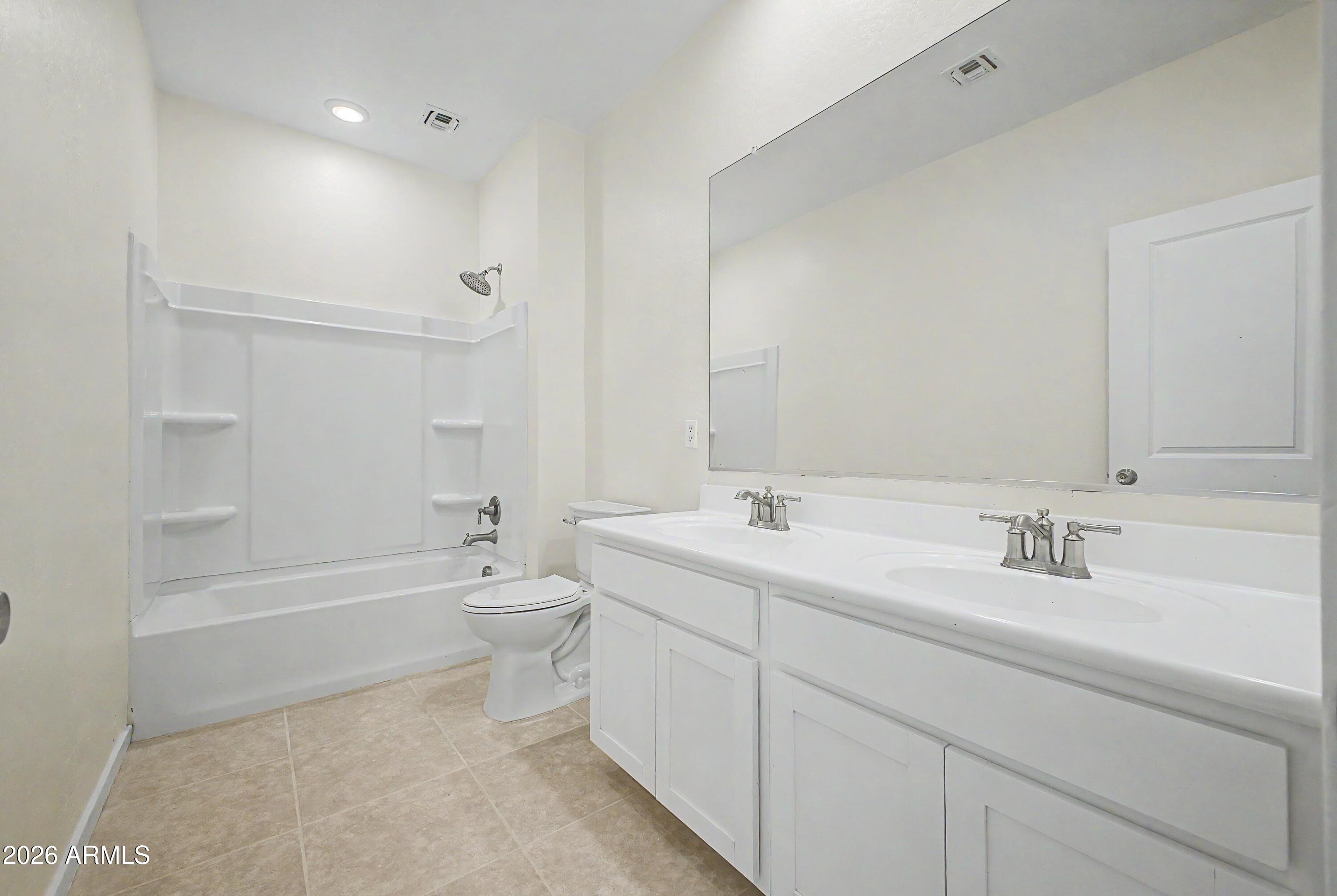 37154 North Navarra Road San Tan Valley, AZ 85140 - Photo 18 of 25 a bathroom with a double vanity sink toilet mirror and bathtub