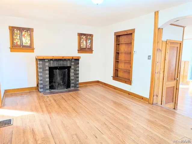 a view of an empty room with glass door and wooden floor