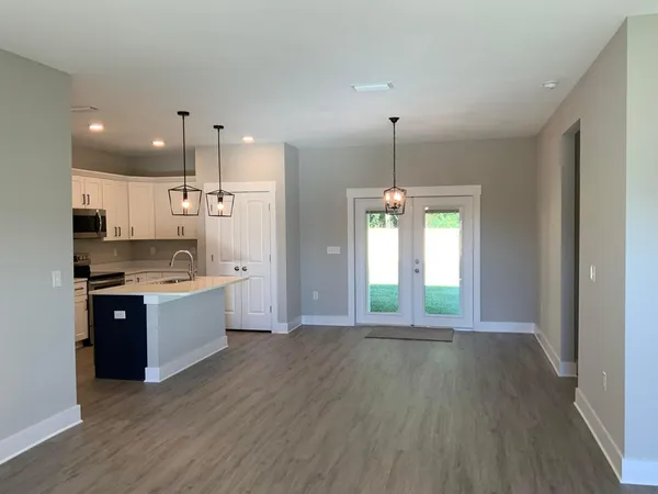 a large kitchen with kitchen island white cabinets and stainless steel appliances