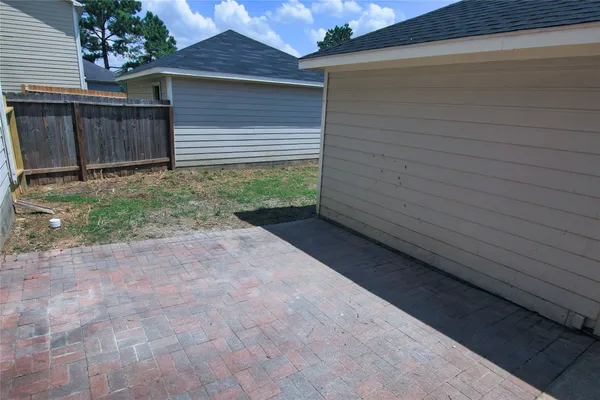 a view of backyard with potted plants and wooden fence