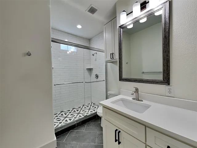 a bathroom with a sink a large mirror and shower