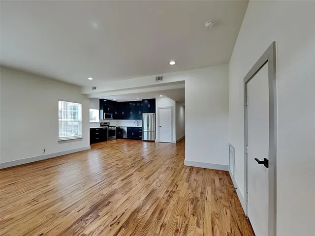 a view of empty room with wooden floor