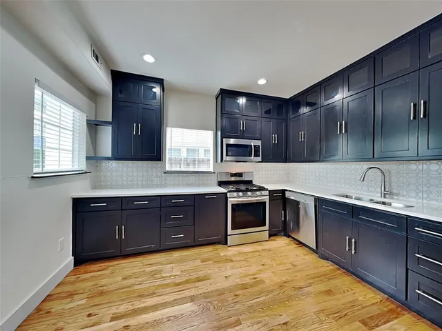 a large kitchen with stainless steel appliances granite countertop a sink stove and cabinets