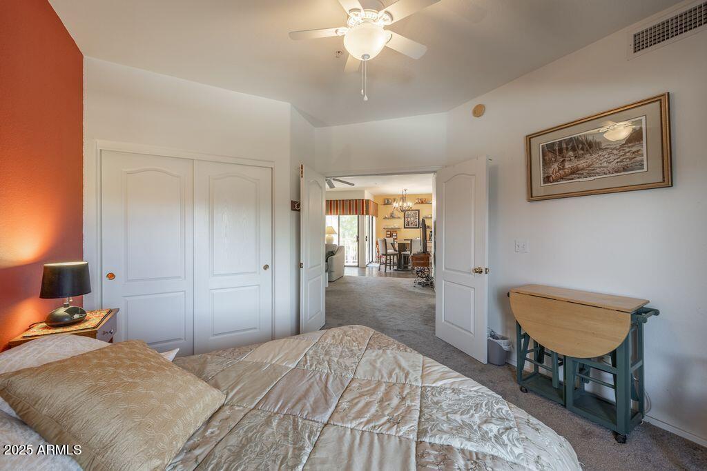 9151 West Greenway Road, Unit 273 Peoria, AZ 85381 - Photo 15 of 24 a bedroom with a bed and a chandelier