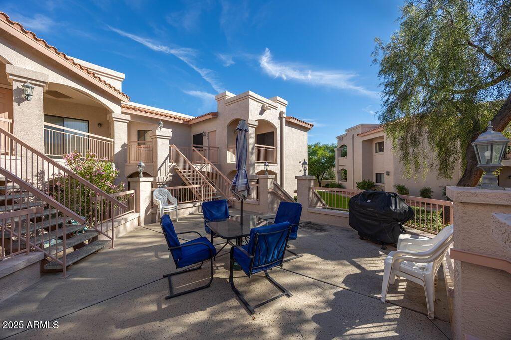 9151 West Greenway Road, Unit 273 Peoria, AZ 85381 - Photo 2 of 24 a view of a patio with a dining table and chairs with wooden floor