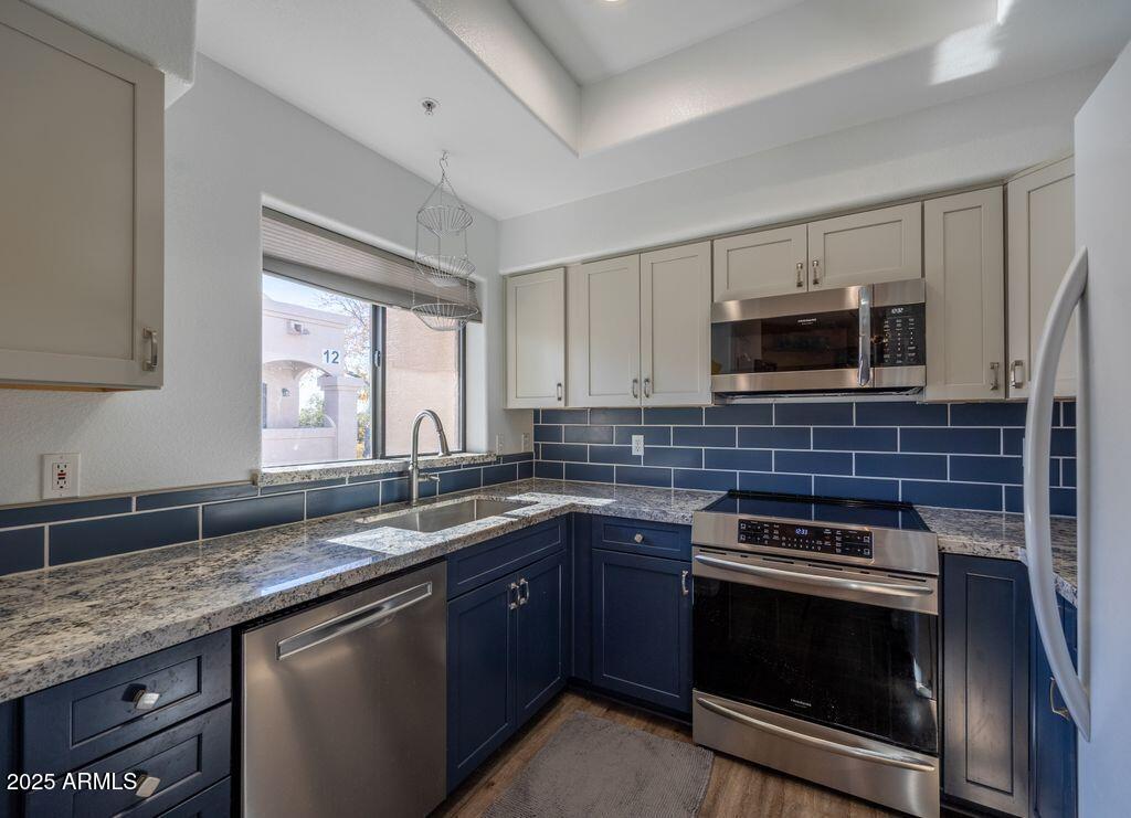 9151 West Greenway Road, Unit 273 Peoria, AZ 85381 - Photo 2 of 24 a kitchen with stainless steel appliances granite countertop a sink stove microwave and cabinets