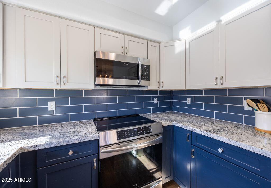 9151 West Greenway Road, Unit 273 Peoria, AZ 85381 - Photo 9 of 24 a kitchen with granite countertop a stove microwave and sink