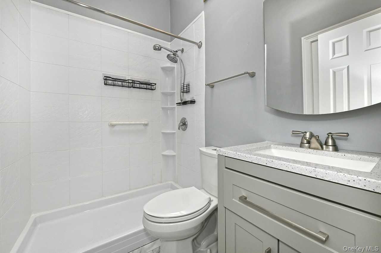 1 Anchorage Way, Unit 1408 Freeport, NY 11520 - Photo 17 of 25 a bathroom with a granite countertop sink toilet and shower