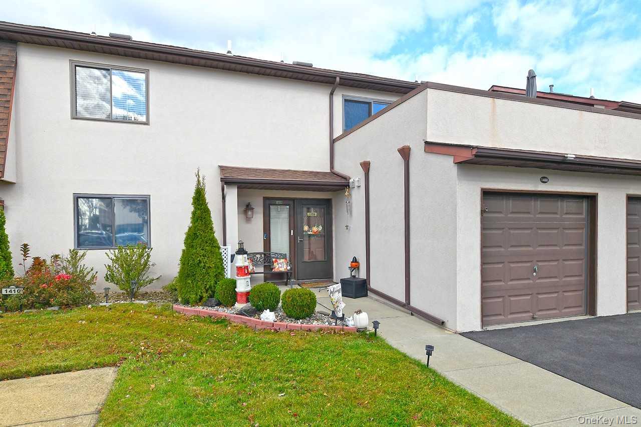 1 Anchorage Way, Unit 1408 Freeport, NY 11520 - Photo 3 of 25 a front view of a house with a yard and potted plants