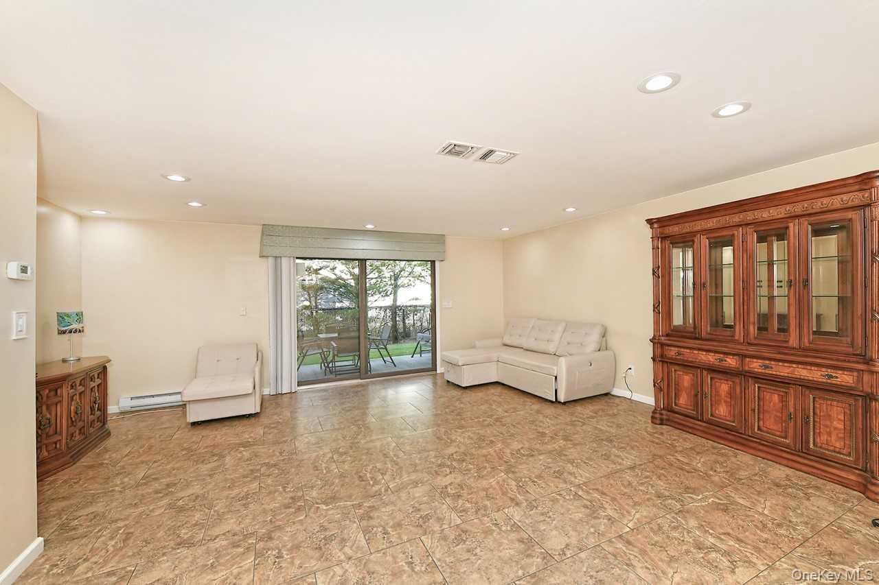 1 Anchorage Way, Unit 1408 Freeport, NY 11520 - Photo 6 of 25 a living room with furniture and large windows