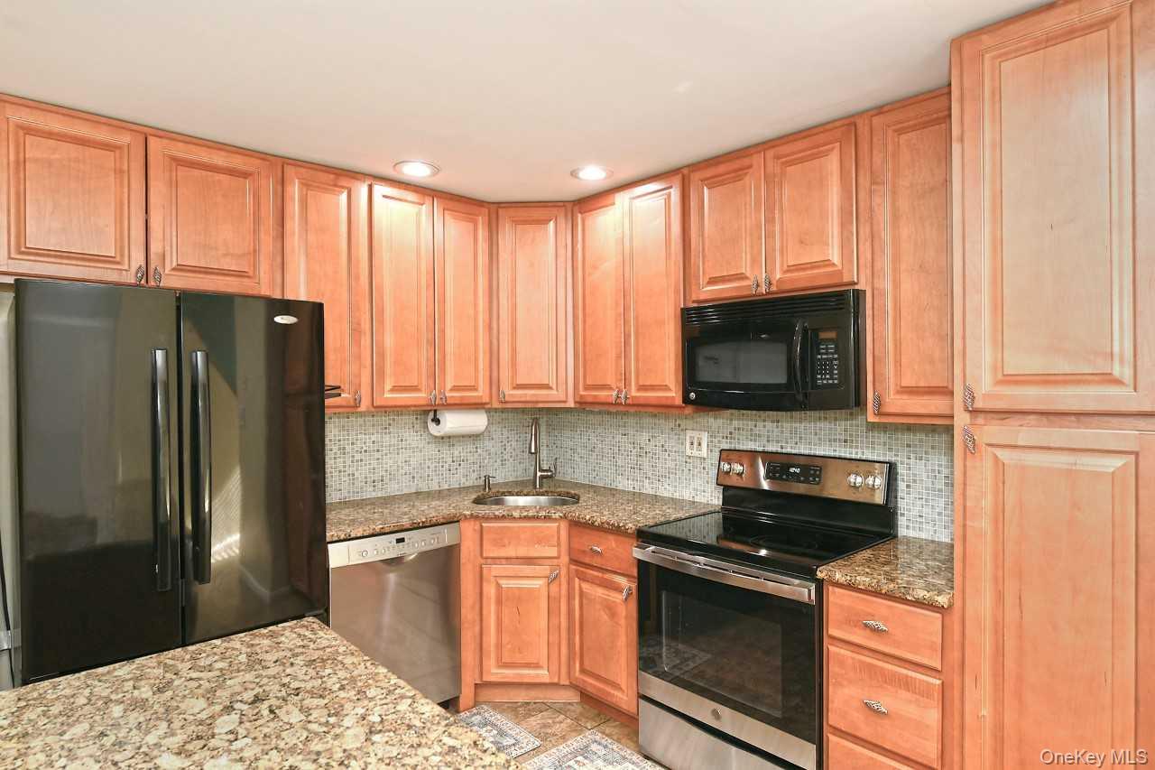 1 Anchorage Way, Unit 1408 Freeport, NY 11520 - Photo 10 of 25 a kitchen with stainless steel appliances granite countertop a refrigerator stove top oven and sink