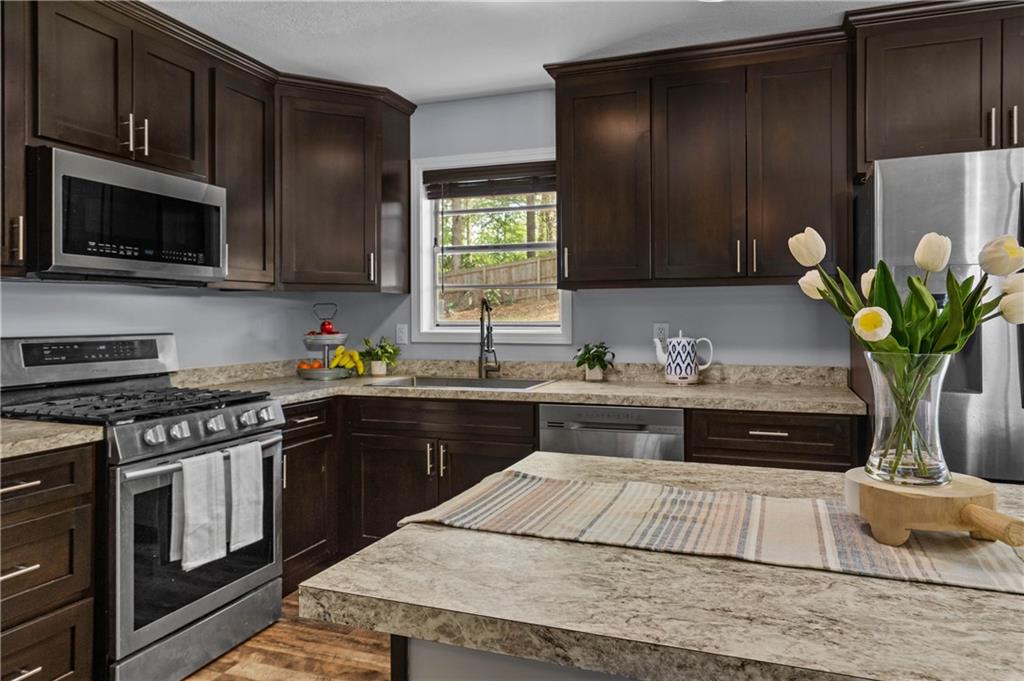 3990 Pine Mountain Road Northwest Kennesaw, GA 30152 - Photo 11 of 32 a kitchen with stainless steel appliances granite countertop a stove a sink and a microwave
